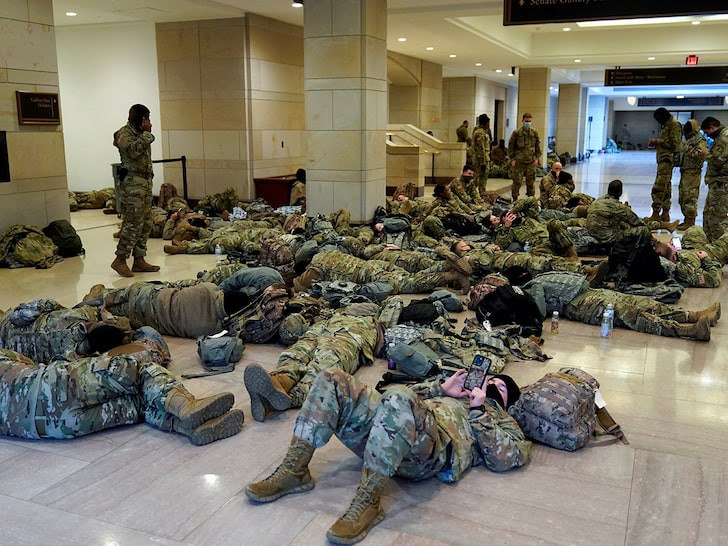 Exhausted US National Guards sleep on Capitol floor with their weapon by their side